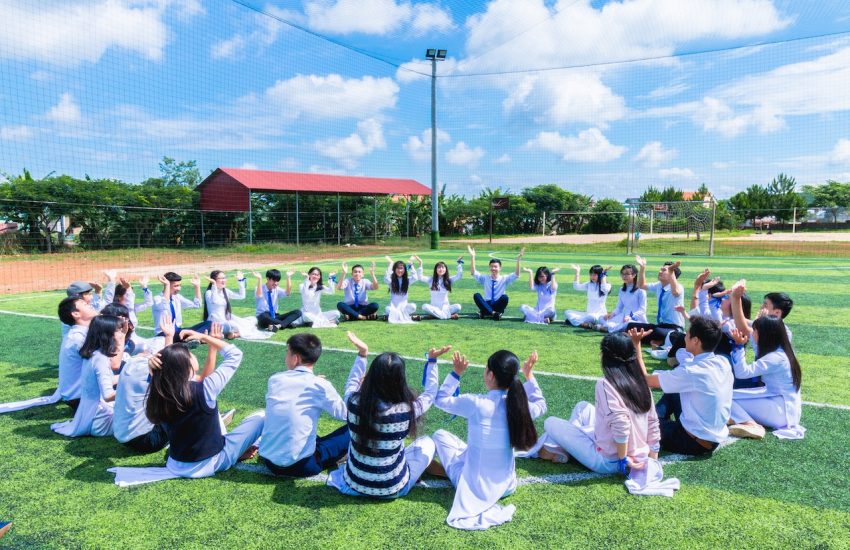 Dzieci siedzące w okręgu na trawie